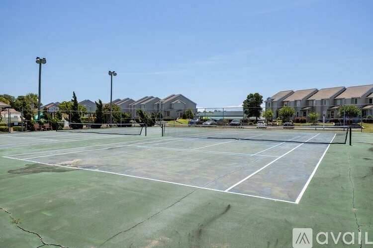 A tennis court with white lines and a logo in the bottom right corner.
