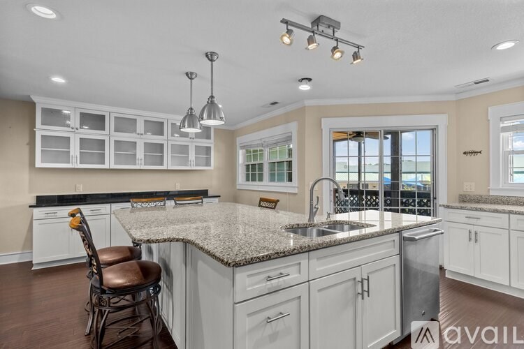 A kitchen with a granite countertop and a bar area.
