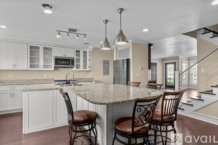 A kitchen with a granite countertop and bar stools.