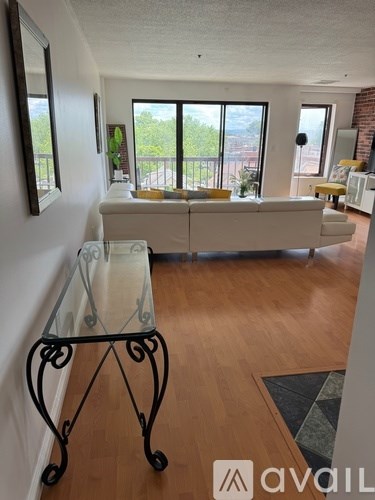 A living room with a glass table and a white sofa.