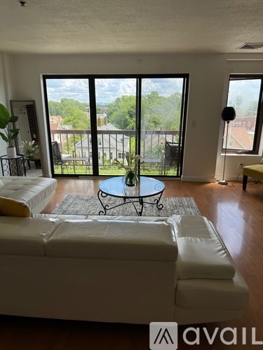 A living room with a white couch and a glass table.
