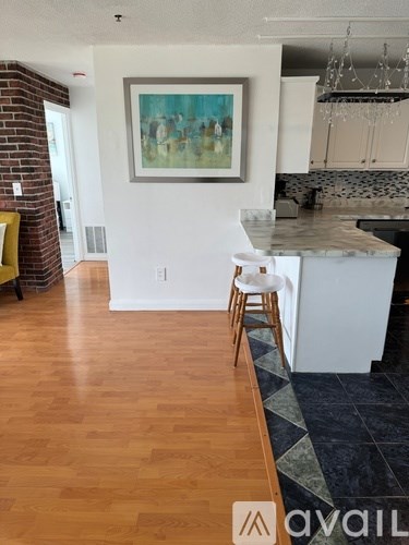 A kitchen with a white counter and a painting on the wall.