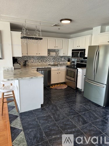 A kitchen with a marble countertop and a refrigerator.