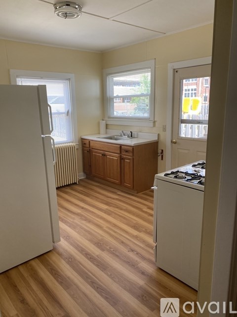 A kitchen with wooden floors and white appliances.