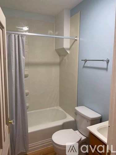 A bathroom with a toilet, sink, and bathtub.