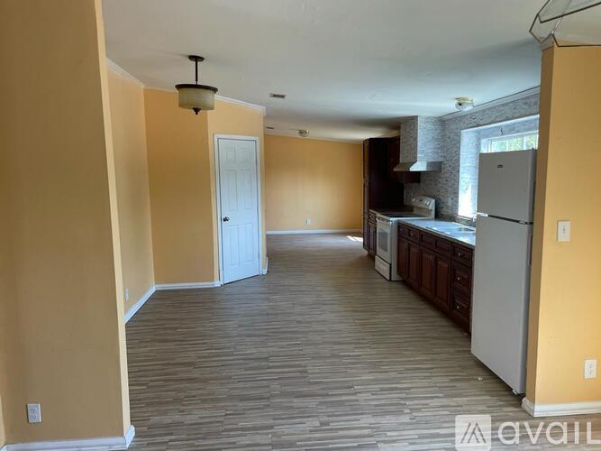 A kitchen area with a refrigerator, oven, and cabinets.