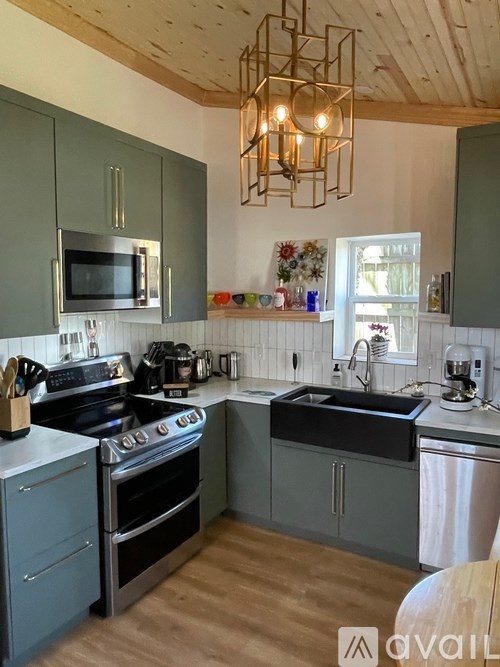 A kitchen with a stove, oven, microwave, and sink.
