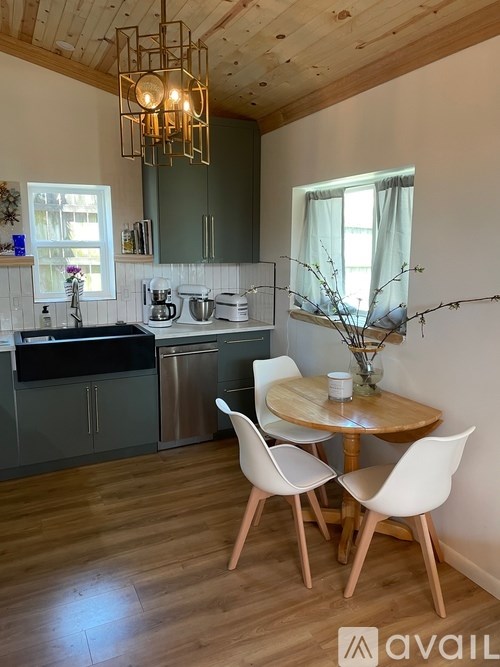 A kitchen with a table and chairs in front of it.