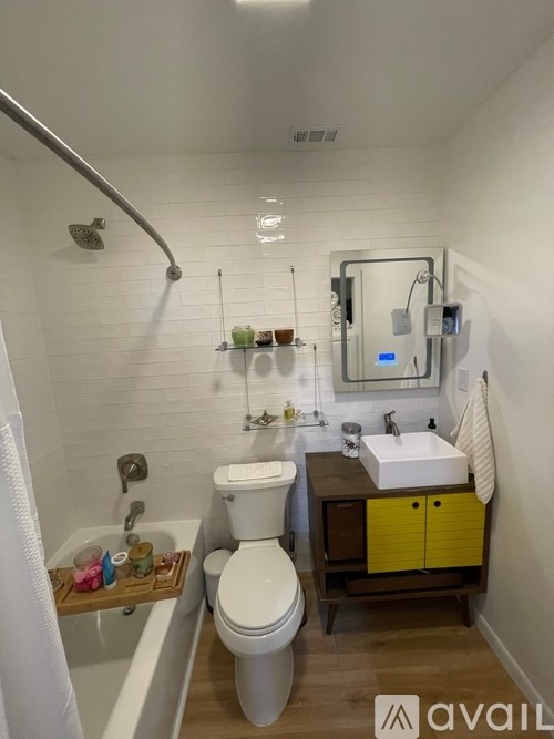 A bathroom with a toilet, sink, and mirror.