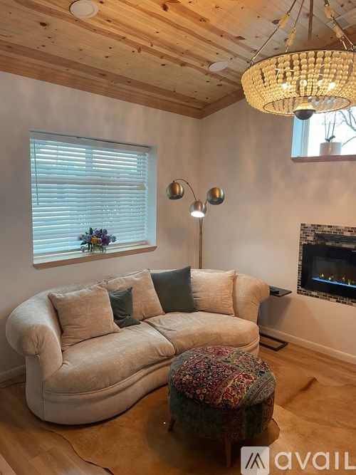A living room with a large couch and a chandelier.