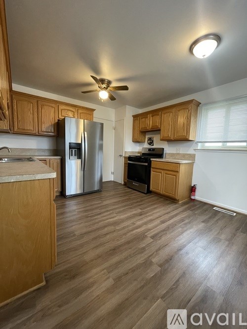 A kitchen with wooden cabinets and a refrigerator.