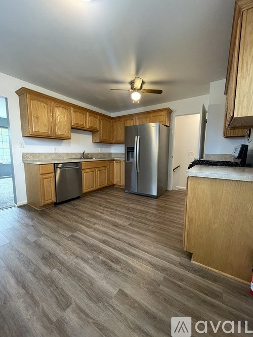 A kitchen with wooden cabinets and a refrigerator.