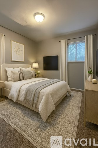 A bedroom with a large bed and a flat screen TV mounted on the wall.