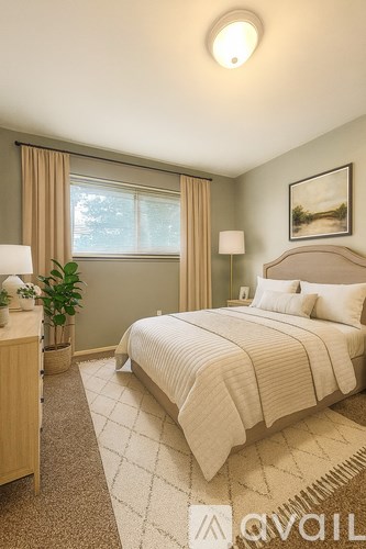 A well-lit bedroom with a large bed and a window with curtains.