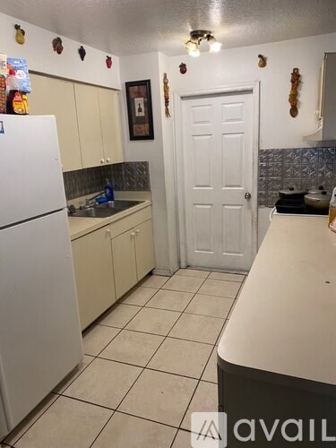 A kitchen with a white refrigerator and a white door.