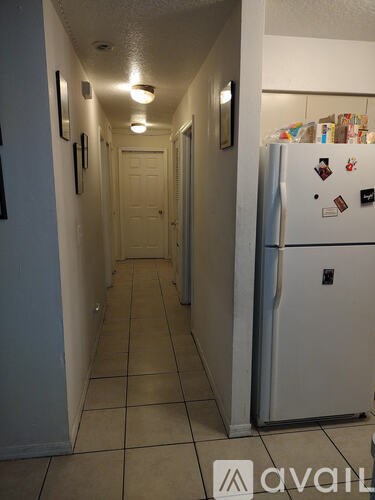 A long hallway with a fridge on the right.
