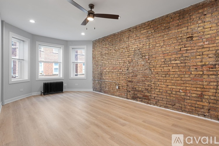 A room with a brick wall and wooden flooring.