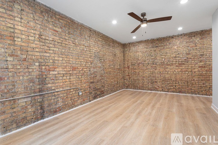 A room with a brick wall and wooden floor.