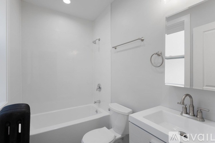 A white bathroom with a toilet, sink, and bathtub.