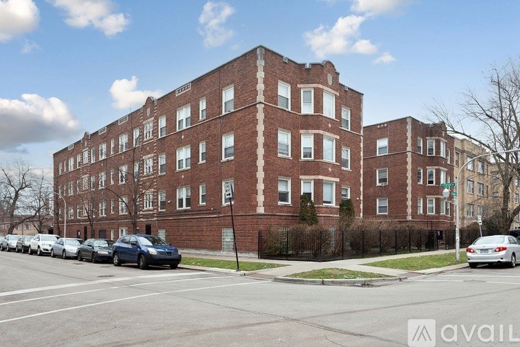 A row of parked cars in front of a red brick building.