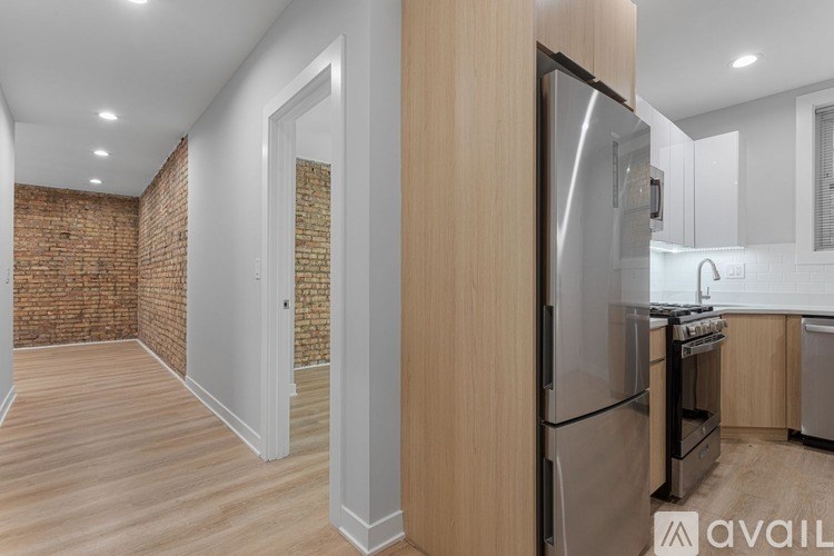 A modern kitchen with a refrigerator, oven, and sink.