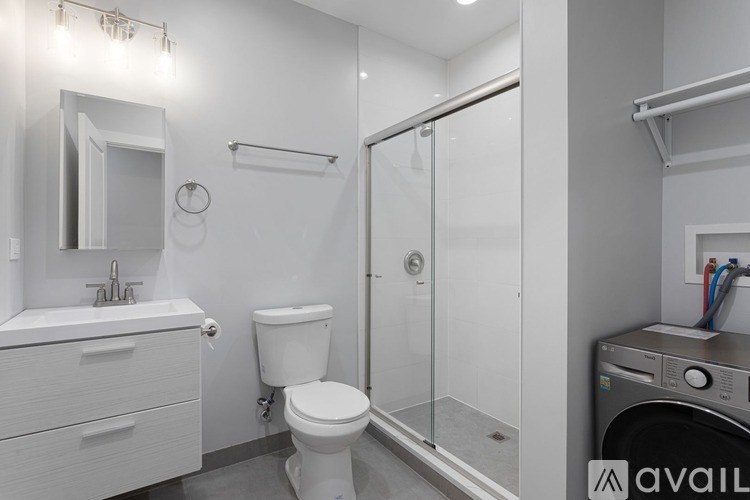 A white bathroom with a toilet, sink, and shower.