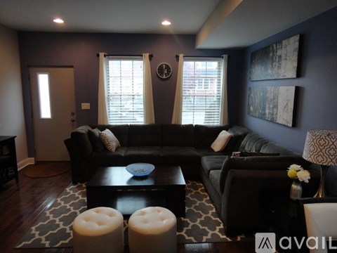 A living room with a black couch and a coffee table.