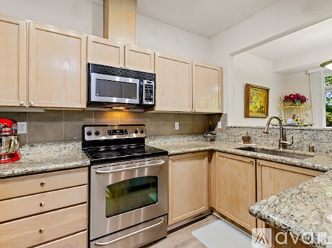 A kitchen with wooden cabinets and granite countertops.