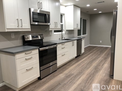 A kitchen with white cabinets and a black stove top oven.