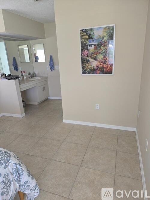 A bathroom with a sink, mirror, and a painting on the wall.