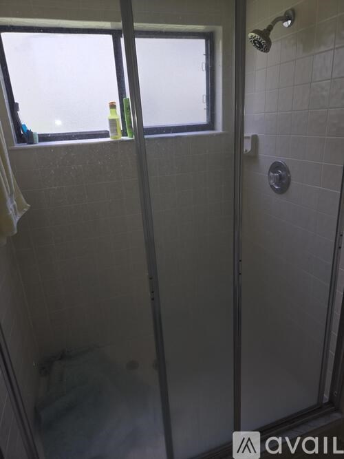 A shower stall with a glass door and a shower head.