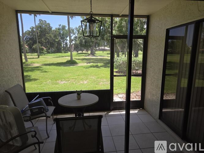 A patio with a table and chairs overlooks a grassy area.