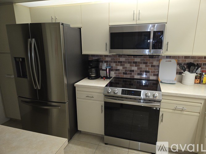 A kitchen with a stainless steel refrigerator, oven, and microwave.