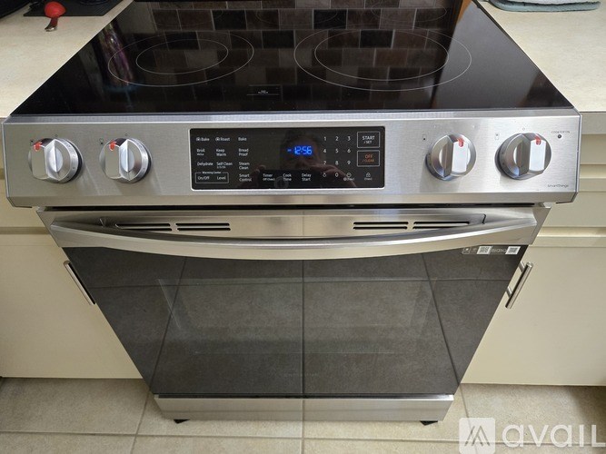 A modern stainless steel oven with a digital control panel and four knobs.