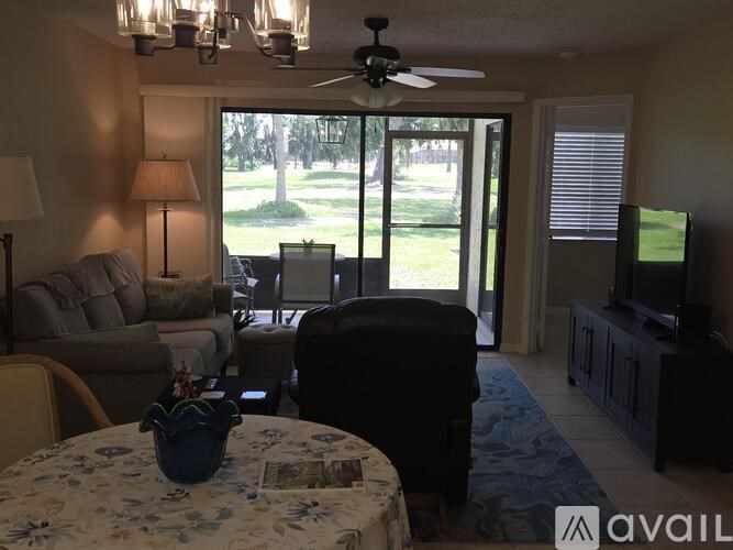 A living room with a couch, chair, and television.