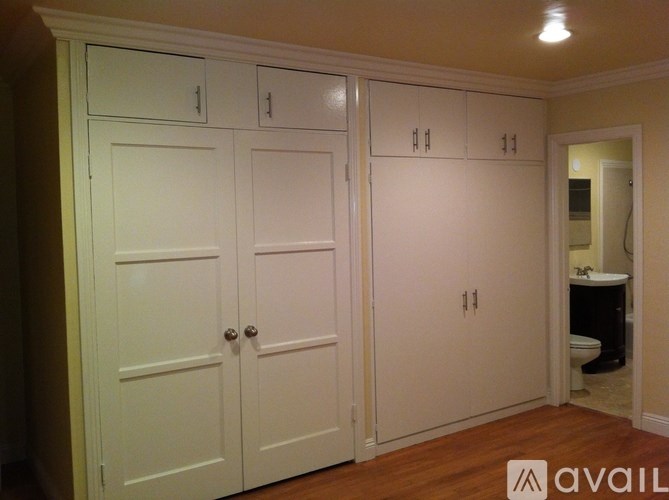 A white cabinet with a mirror in the background.