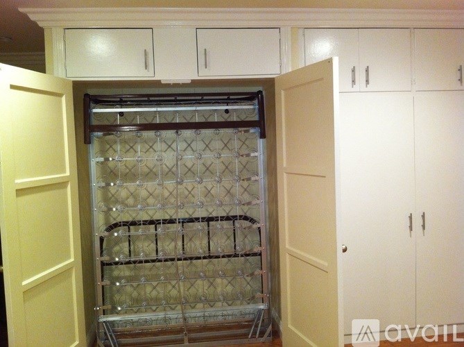 A kitchen with white cabinets and a glass door cabinet.