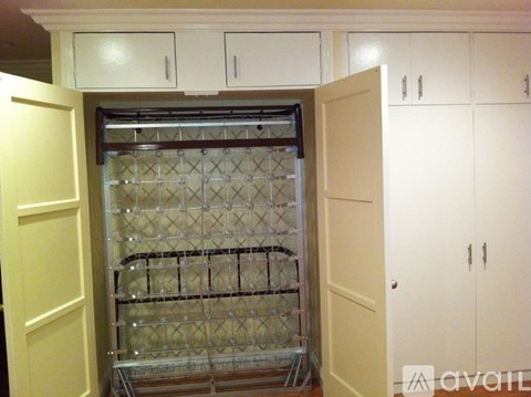 A kitchen with white cabinets and a glass door cabinet.