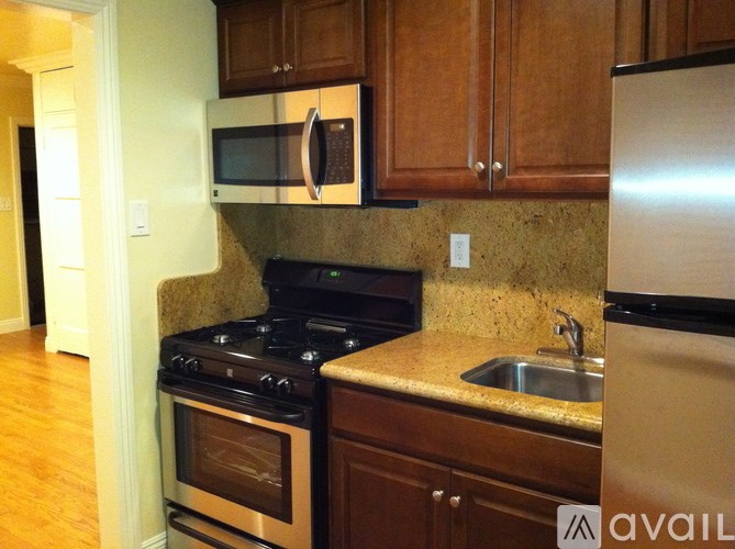 A kitchen with a stove, oven, microwave, and refrigerator.