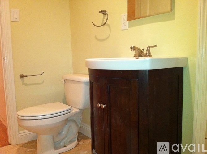 A bathroom with a toilet, sink, and medicine cabinet.