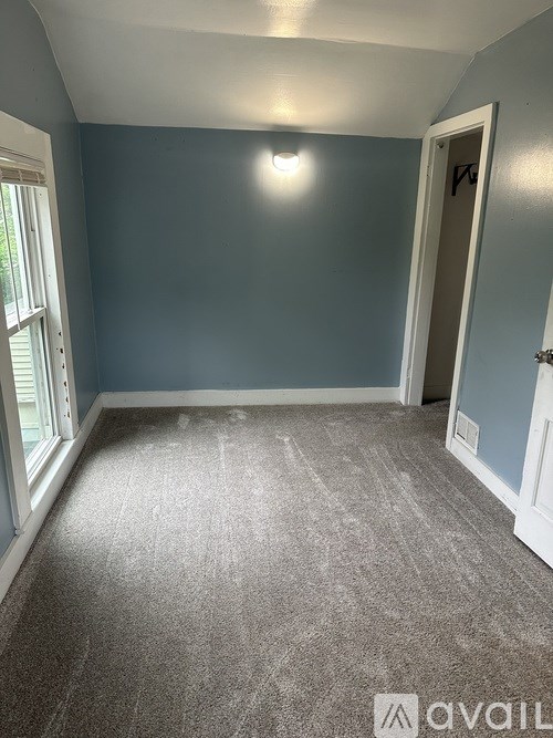 A room with a carpeted floor and a door.