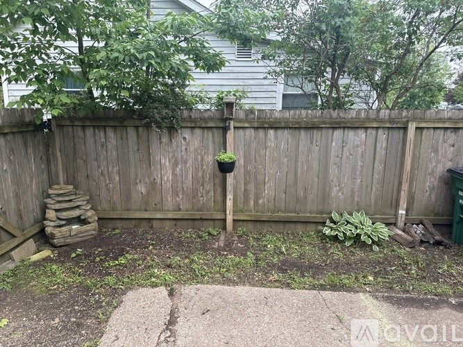 A backyard with a wooden fence and a small garden.