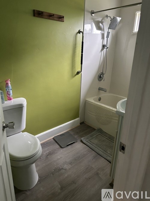 A bathroom with a green wall and a white toilet.