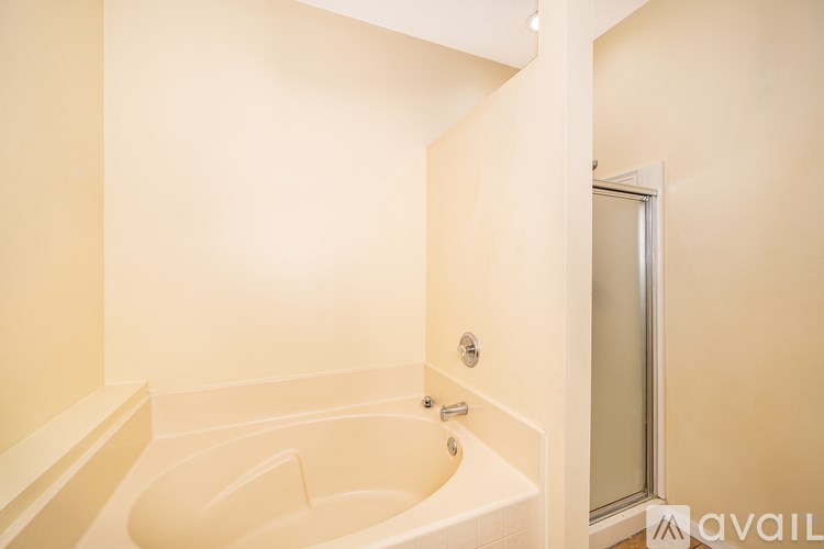 A white bathtub with a shower door in a bathroom.