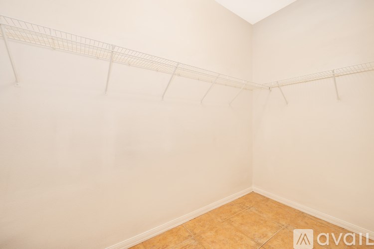 Empty room with a white wall and a wooden floor.