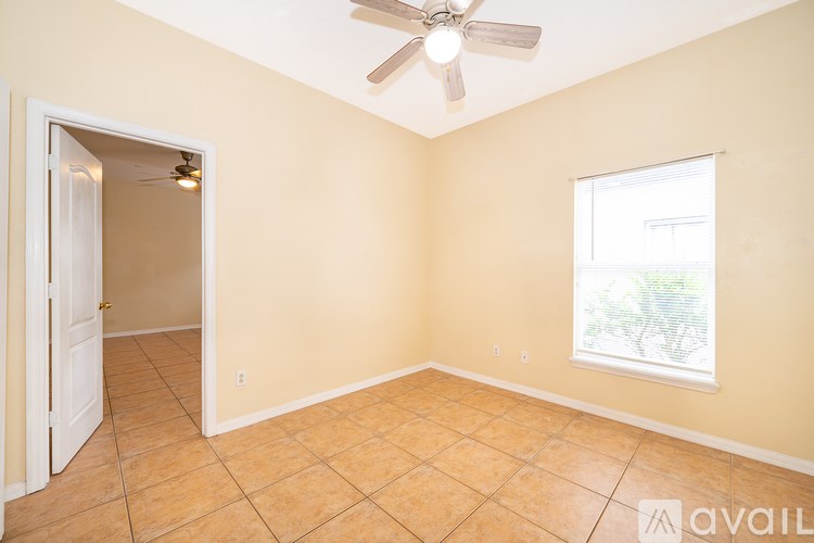 A room with a ceiling fan and a window.
