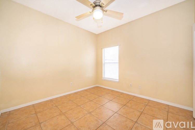A room with a ceiling fan and tile flooring.