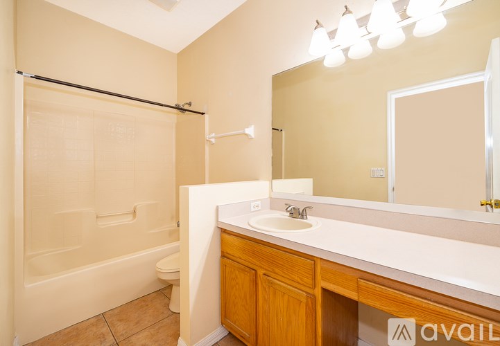 A bathroom with a white countertop and a wooden cabinet.