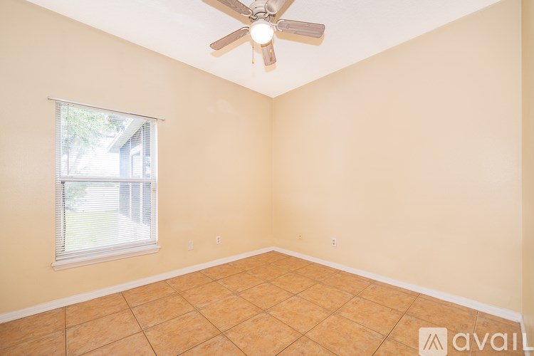 A room with a ceiling fan and a window.
