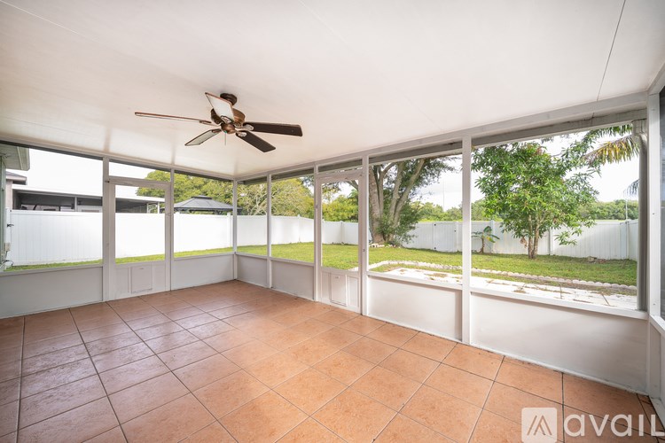 A room with a ceiling fan and tiled floor.